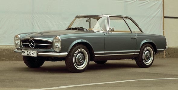 Der Mercedes-Benz 230 SL erscheint 1963 mit ungewohnten neuen Proportionen und Linien – und dem unverwechselbaren „Pagodendach“. Das abnehmbare Hardtop sieht nicht nur gut aus, seine spezielle Form mit leicht abgesenktem Mittelteil erhöht auch die Dachsteifigkeit und damit die Sicherheit. Zu den praktischen Vorteilen zählt auch die leichtere und stabilere Montagemöglichkeit eines Dachträgers, beispielsweise zum Transport von Skiern. Die vertikalen Hauptscheinwerfer hat Mercedes-Benz bereits 1957 beim 300 SL Roadster eingeführt und in weiteren Modellen fortgesetzt. Sie dienen als typisches Marken-Erkennungszeichen in der Frontansicht.